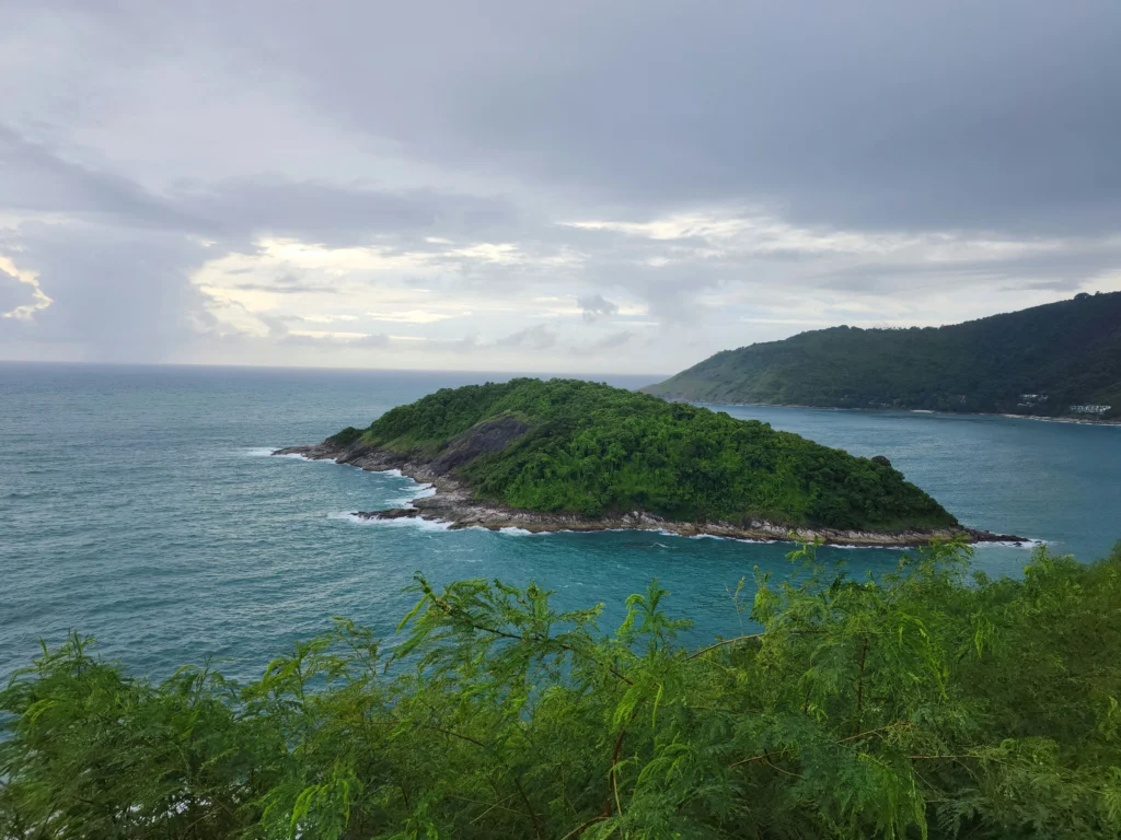 A lush green island surrounded by turquoise ocean waters in Phuket, Thailand.